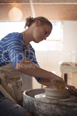 Beautiful female potter making pot