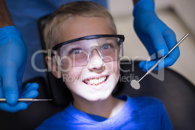 Dentist examining a young patient with tools