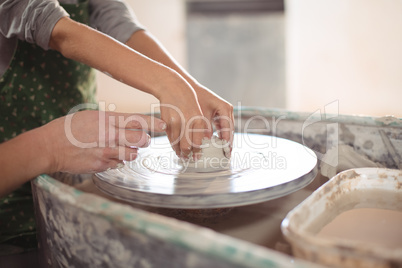 Female potter assisting girls