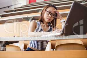 Tensed woman using laptop in classroom