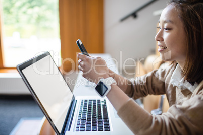 Young woman text message on mobile phone in classroom