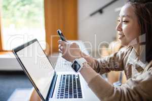 Young woman text message on mobile phone in classroom