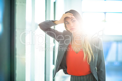 Tired businesswoman leaning on wall