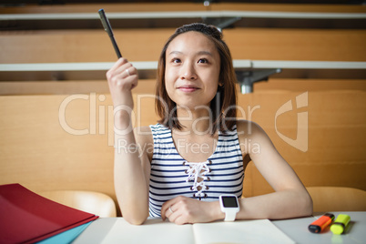 Young woman raising hand in classroom