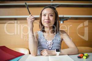 Young woman raising hand in classroom