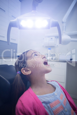 Young patient sitting on dentists chair with mouth open