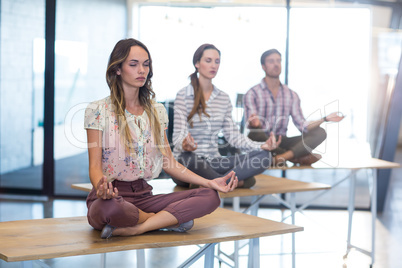 Business people performing yoga on table