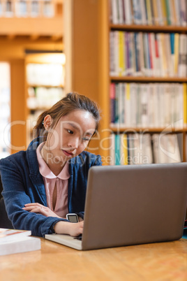 Young woman using laptop in library