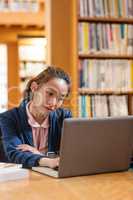 Young woman using laptop in library