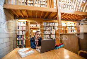 Young woman using laptop in library