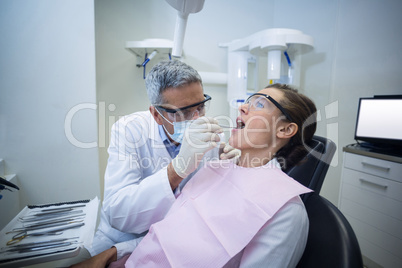 Dentist examining a woman with tools