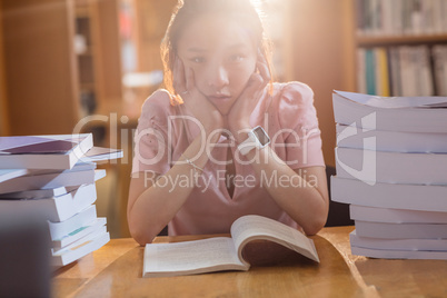 Sad young woman studying in library