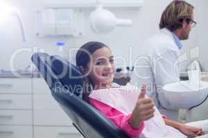 Smiling young patient sitting on dentists chair