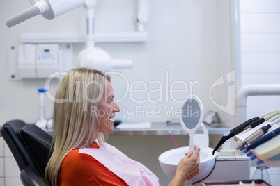 Patient checking her teeth in mirror