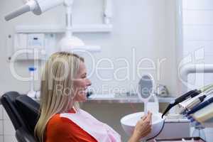 Patient checking her teeth in mirror