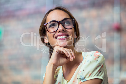 Smiling business executive with hand on chin in office