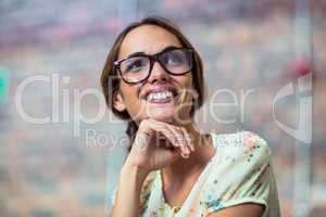 Smiling business executive with hand on chin in office