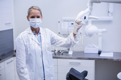 Female dentist holding dental lights