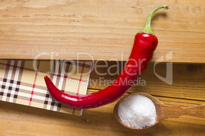 Chili pepper and salt in a wooden spoon