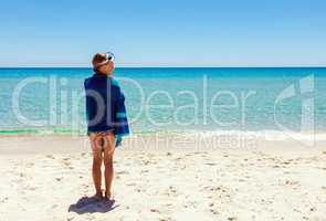 Teenage girl standing alone on the beach