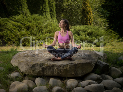 Girl meditates in the lotus position.