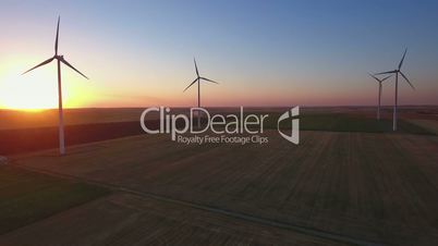 Aerial view of large wind turbines in a wind farm at sunset
