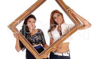 Two women holding picture frame.