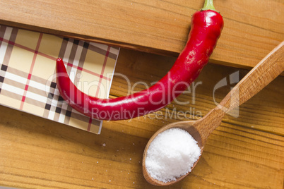 Chili pepper and salt in a wooden spoon