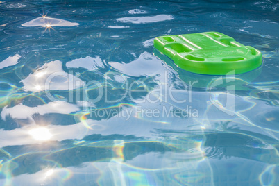 Green lifesaver floating in a swimming pool