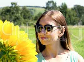 young woman in sunglasses on the nature, sunflower reflected in glasses