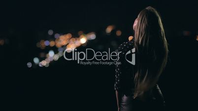 Woman enjoying night city from observation deck