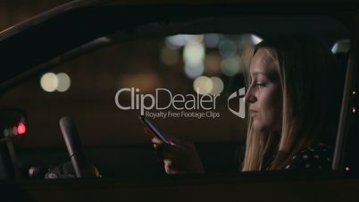 Charming woman texting message on cellphone in car