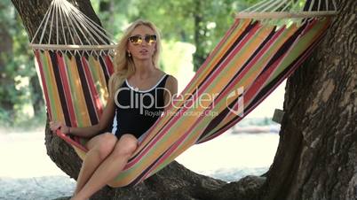 Young lady relaxing on hammock on a beach