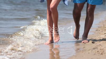 Closeup of feet walking in waters edge on beach