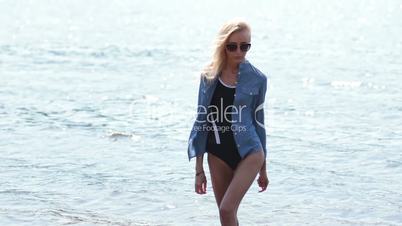 Young cheerful woman coming out of water from sea