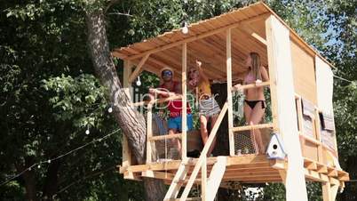 Friends on vacation looking at sea from tree house