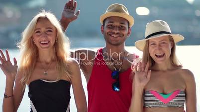 Smiling group of people waving hello with hands