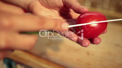 Close up woman hands peeling tomato