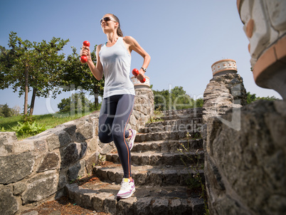 Girl is engaged in fitness dumbbells.