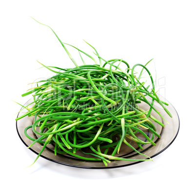 Fresh garlic scapes on glass plate