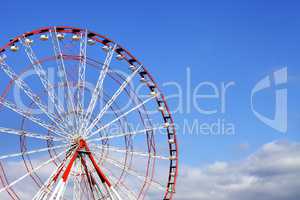 Ferris wheel and blue sky with clouds