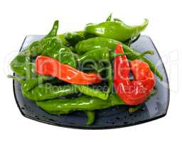 Green and red chili peppers on glass plate