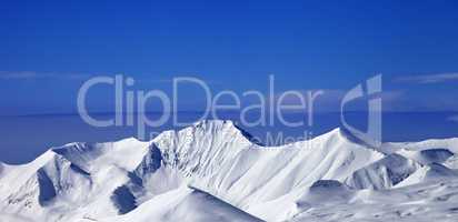 Panoramic view on snow mountains and blue sky