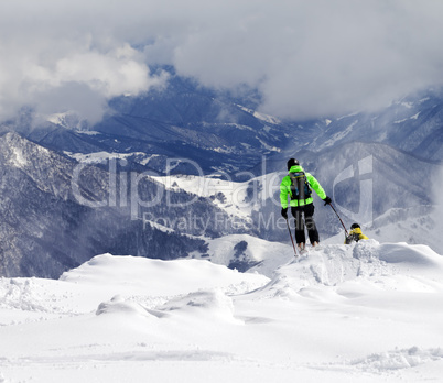 Freeriders on off-piste slope and mountains in mist