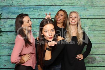 4 hübsche Mädchen albern vor einer Fotobox herum