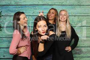 4 hübsche Mädchen albern vor einer Fotobox herum