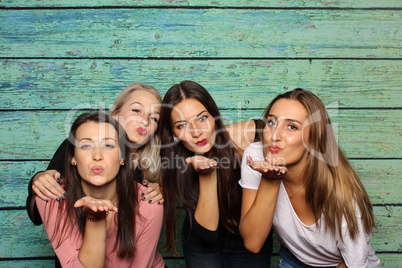 4 Mädchen machen Pusteküsse in eine Fotobox