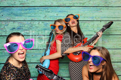 Mädchengruppe mit Plastikgitarren vor Fotobox - Party mit Photobooth