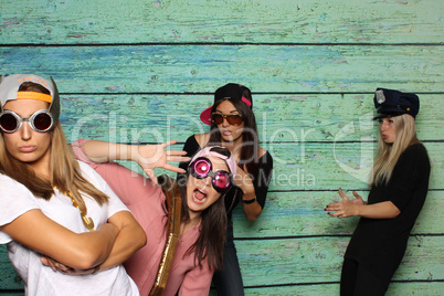 Verrückte Mädchen mit Brillen und Mützen vor einer Fotobox - Albern sein mit Photobooth