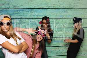 Verrückte Mädchen mit Brillen und Mützen vor einer Fotobox - Albern sein mit Photobooth